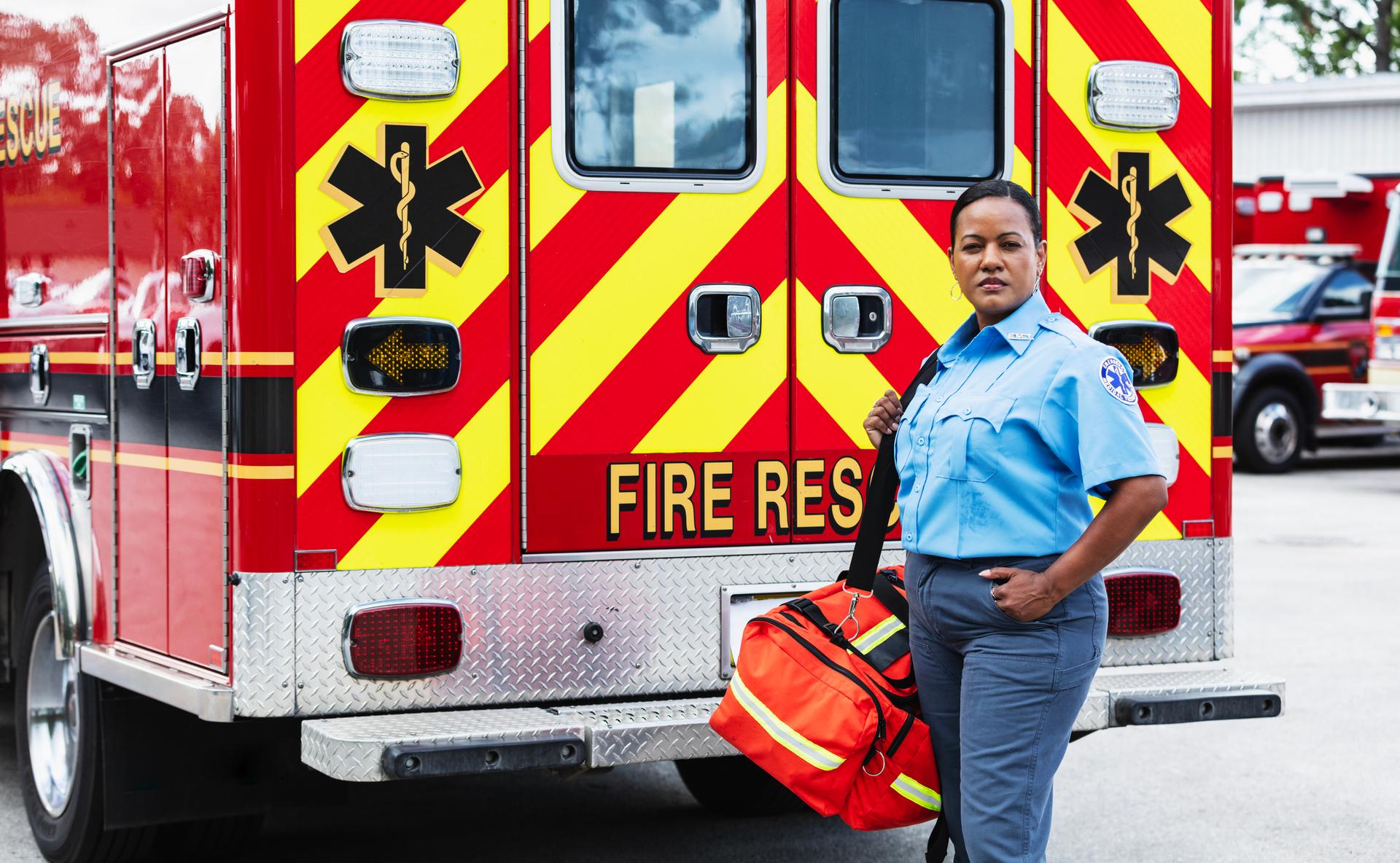 Emergency medical services (EMS) standing outside fire rescue ambulance