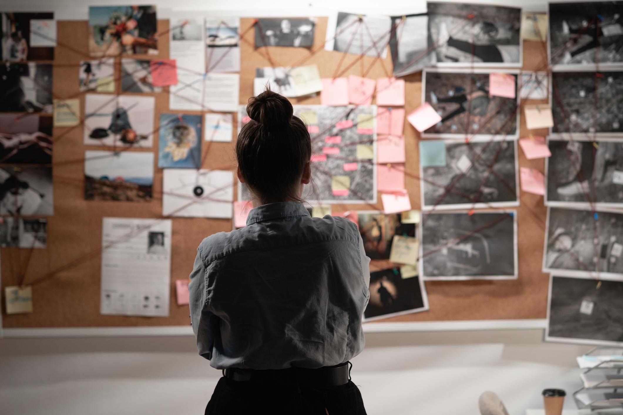 Female detective looking at investigation board
